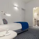 Chambre triple avec une couverture à rayures bleues et blanches sur le lit à l’Hôtel 34B