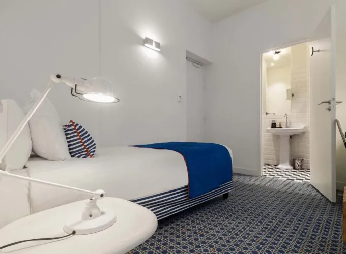 Chambre triple avec une couverture à rayures bleues et blanches sur le lit à l’Hôtel 34B