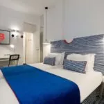 Chambre triple avec un lit et une télévision à l’Hôtel 34B
