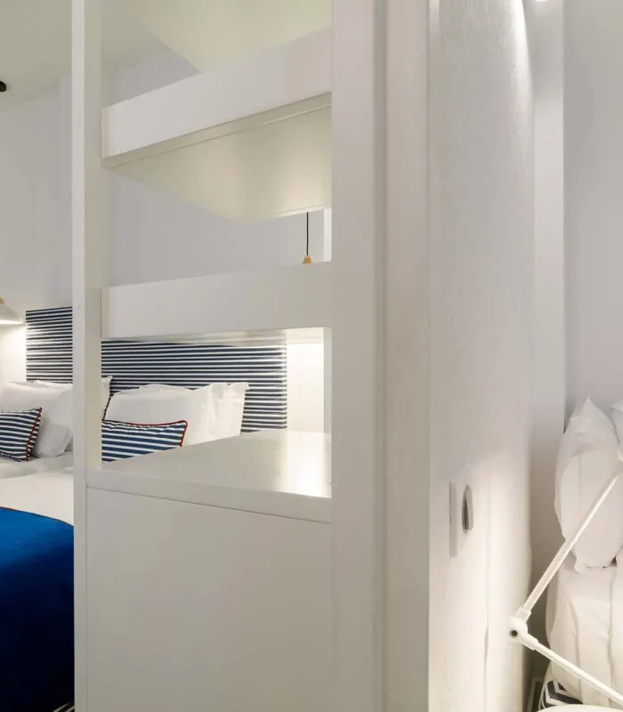 Chambre triple avec un lit bleu et des oreillers blancs à l’Hôtel 34B
