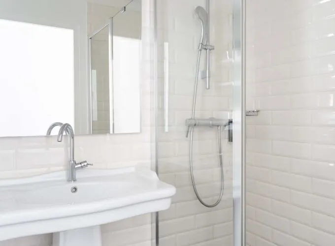 Salle de bain de la chambre triple avec un lavabo, un miroir et une douche à l’Hôtel 34B