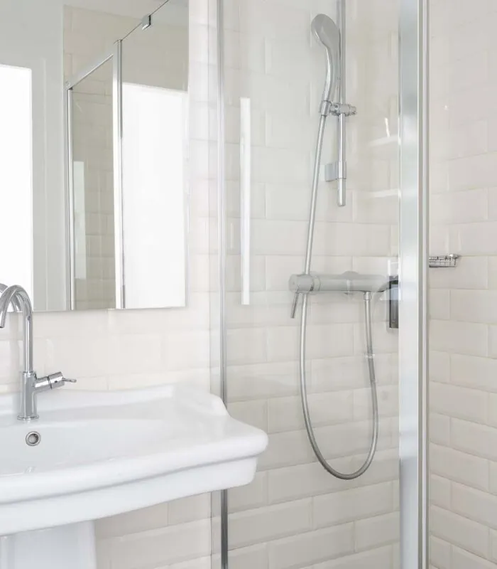 Salle de bain de la chambre triple avec un lavabo, un miroir et une douche à l’Hôtel 34B