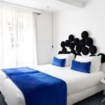 Chambre twin avec deux lits et une couverture bleue à l’Hôtel 34B