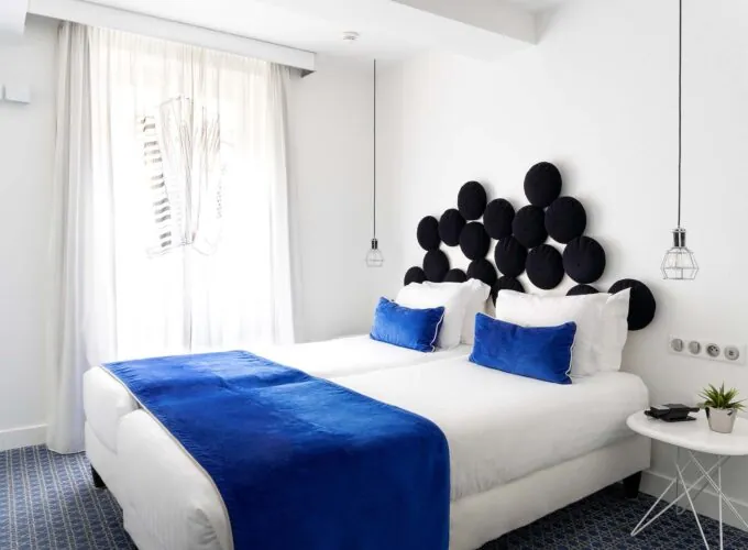 Chambre twin avec deux lits et une couverture bleue à l’Hôtel 34B