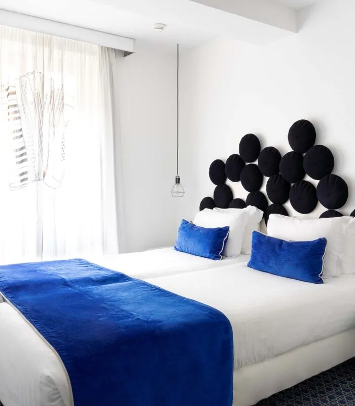 Chambre twin avec deux lits et une couverture bleue à l’Hôtel 34B