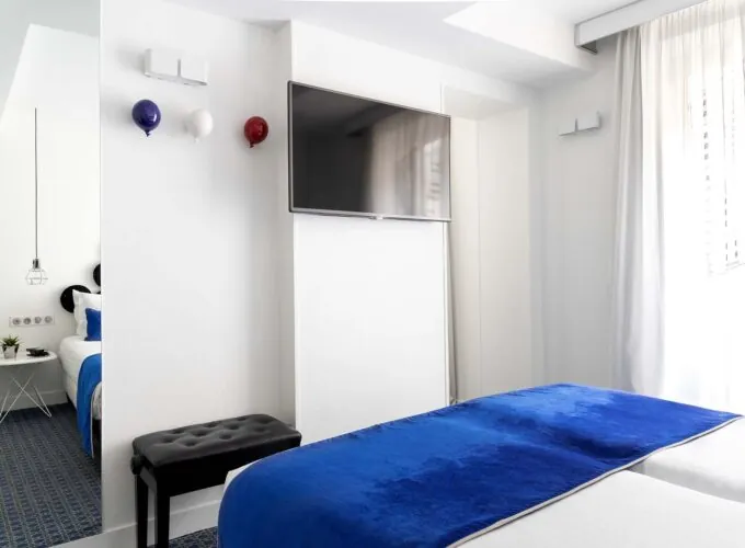 Chambre twin avec deux lits et une télévision à écran plat à l’Hôtel 34B