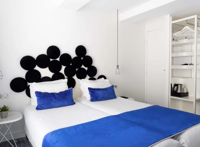 Chambre twin avec une couverture bleue sur le lit à l’Hôtel 34B