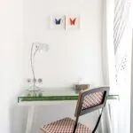 Bureau de la chambre twin avec deux tableaux de papillons accrochés au mur au-dessus à l’Hôtel 34B