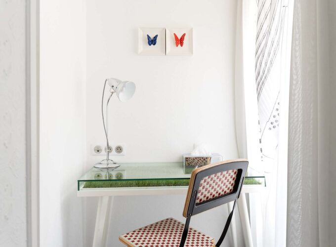 Bureau de la chambre twin avec deux tableaux de papillons accrochés au mur au-dessus à l’Hôtel 34B