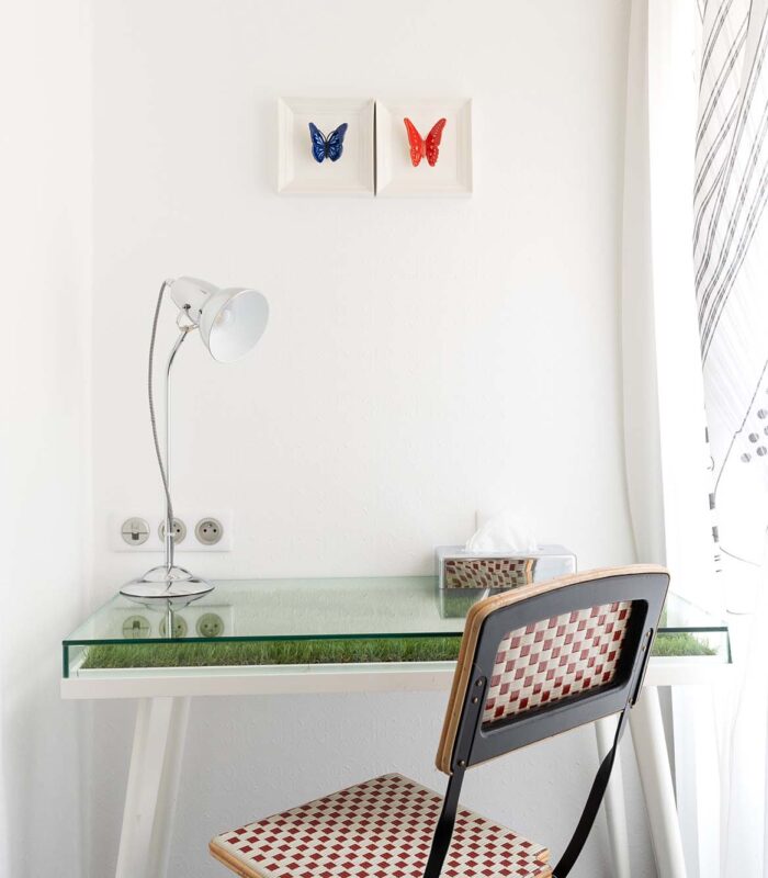 Bureau de la chambre twin avec deux tableaux de papillons accrochés au mur au-dessus à l’Hôtel 34B