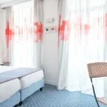 Chambre Twin Supérieure avec deux lits et une chaise, avec un tableau de papillon sur le mur à l’Hôtel 34B