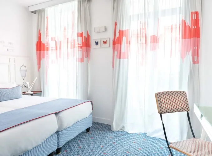 Chambre Twin Supérieure avec deux lits et une chaise, avec un tableau de papillon sur le mur à l’Hôtel 34B