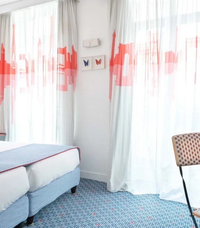 Chambre Twin Supérieure avec deux lits et une chaise, avec un tableau de papillon sur le mur à l’Hôtel 34B
