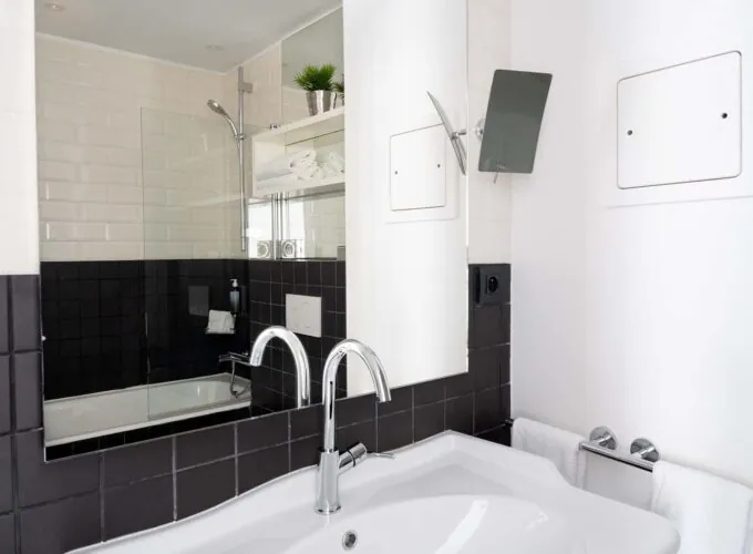 Salle de bain de la Chambre Twin Supérieure avec des carreaux noirs et blancs et un lavabo à l’Hôtel 34B