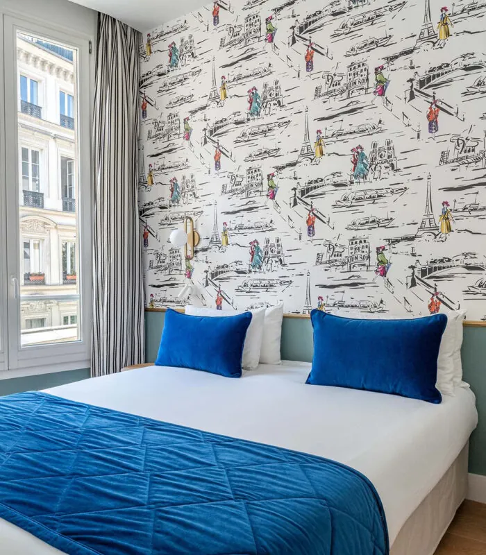 Chambre Double avec un lit et des oreillers bleus à l’hôtel Acadia