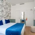 Chambre Double avec un lit et une télévision à l’hôtel Acadia