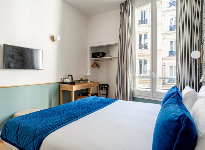 Chambre Double avec un lit, un bureau et une télévision à écran plat à l’hôtel Acadia