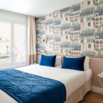 Chambre Double avec un lit et une couverture bleue à l’hôtel Acadia