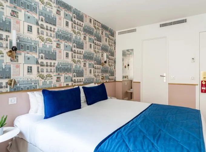 Chambre Double avec un lit et des oreillers bleus à l’hôtel Acadia