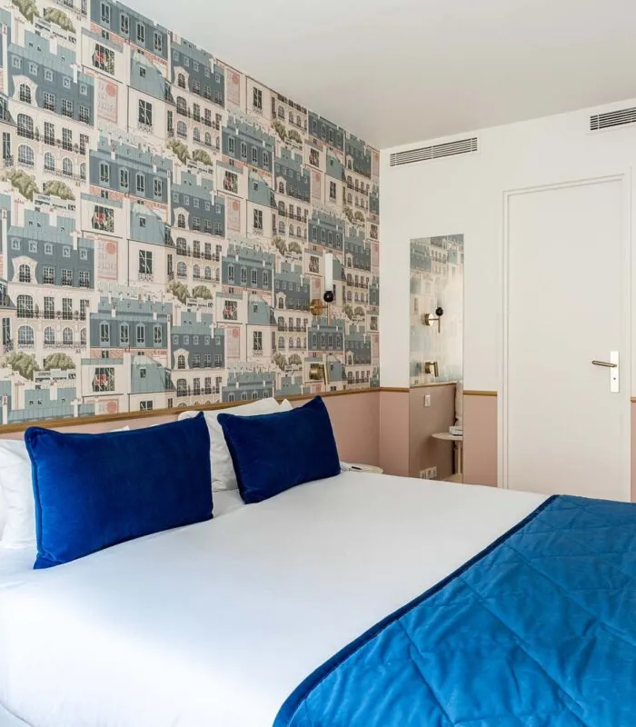 Chambre Double avec un lit et des oreillers bleus à l’hôtel Acadia