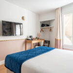 Chambre Double avec un lit, un bureau et une télévision à écran plat à l’hôtel Acadia