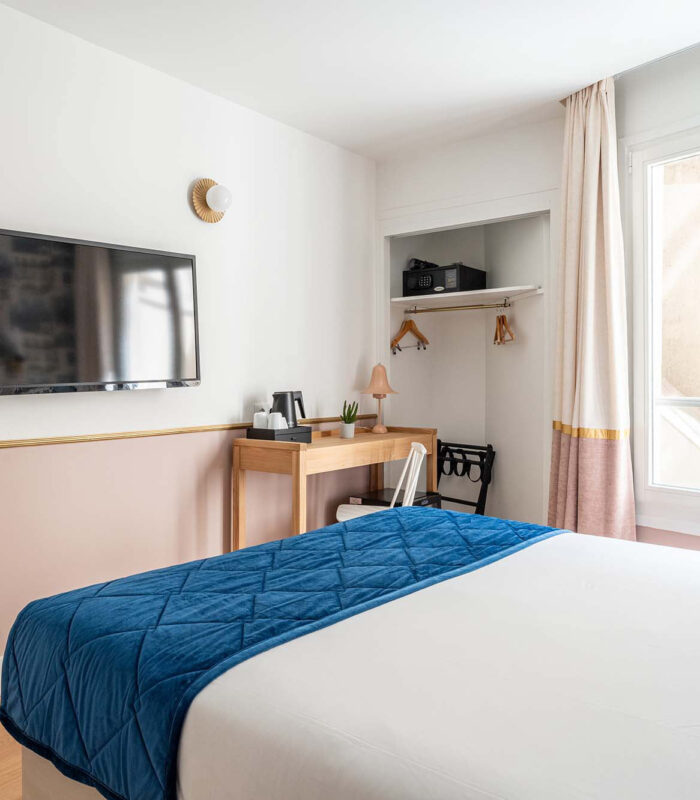 Chambre Double avec un lit, un bureau et une télévision à écran plat à l’hôtel Acadia