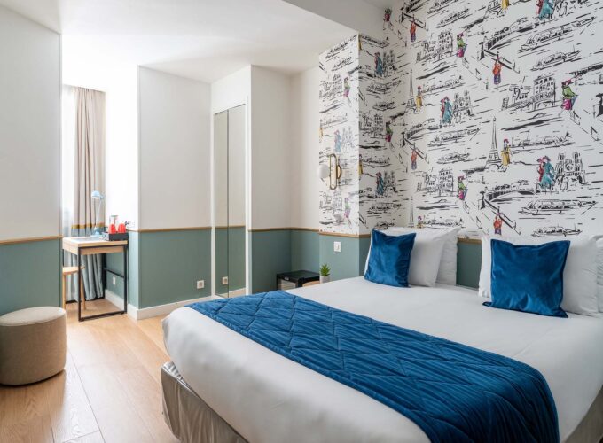 Chambre familiale avec un lit et des oreillers bleus à l’Hôtel Acadia