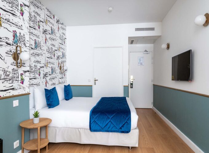 Chambre familiale avec une couverture bleue sur le lit à l’Hôtel Acadia