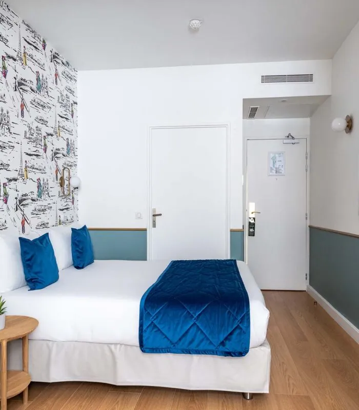 Chambre familiale avec une couverture bleue sur le lit à l’Hôtel Acadia