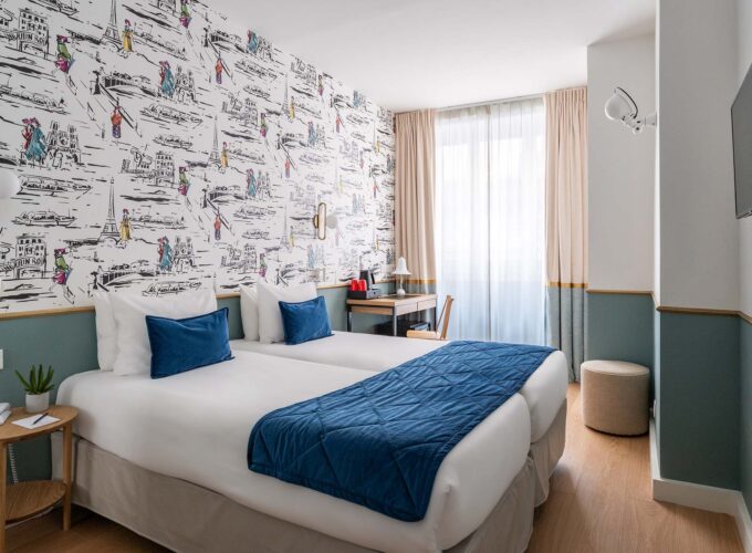 Chambre familiale avec deux lits et un bureau à l’Hôtel Acadia