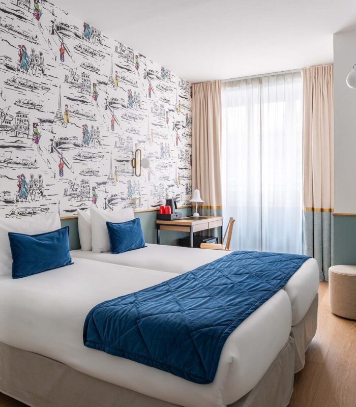 Chambre familiale avec deux lits et un bureau à l’Hôtel Acadia