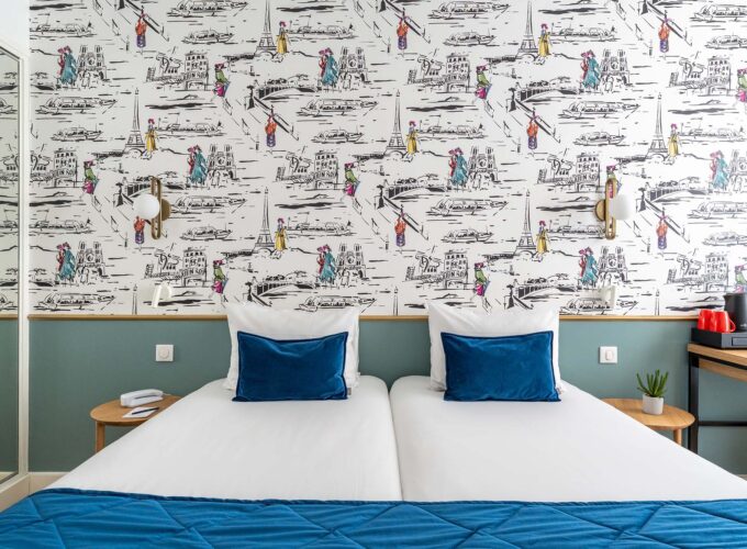 Chambre familiale avec deux lits et une couverture bleue à l’Hôtel Acadia