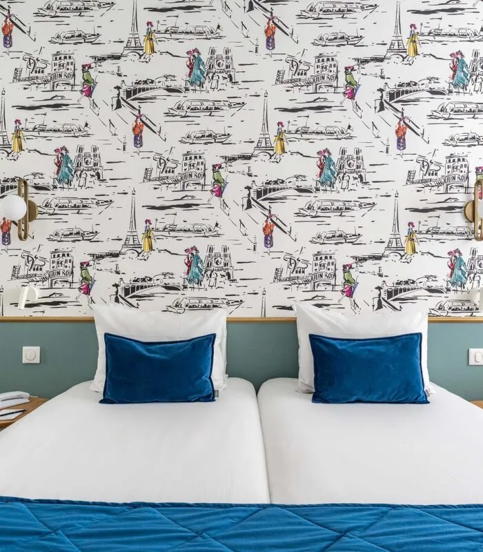 Chambre familiale avec deux lits et une couverture bleue à l’Hôtel Acadia