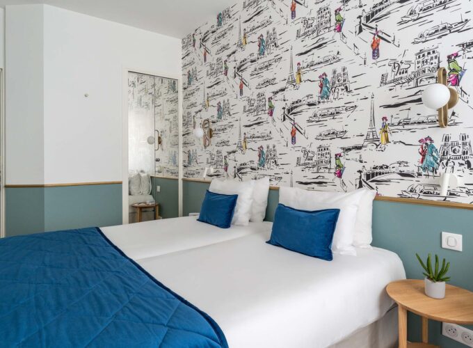 Chambre familiale avec deux lits et un papier peint coloré à l’Hôtel Acadia