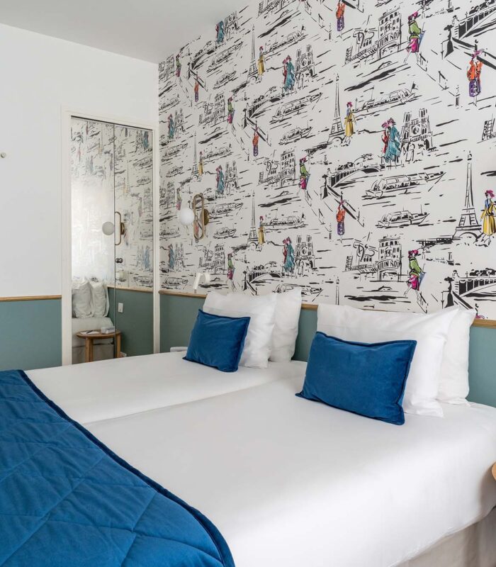 Chambre familiale avec deux lits et un papier peint coloré à l’Hôtel Acadia