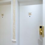 Chambre familiale avec deux portes blanches portant les lettres i et ii à l’Hôtel Acadia