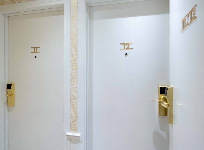 Chambre familiale avec deux portes blanches portant les lettres i et ii à l’Hôtel Acadia