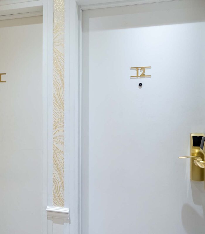 Chambre familiale avec deux portes blanches portant les lettres i et ii à l’Hôtel Acadia