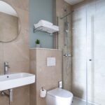 Salle de bain d’une chambre familiale avec un toilette, un lavabo et un miroir à l’Hôtel Acadia