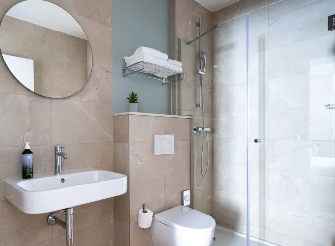 Salle de bain d’une chambre familiale avec un toilette, un lavabo et un miroir à l’Hôtel Acadia