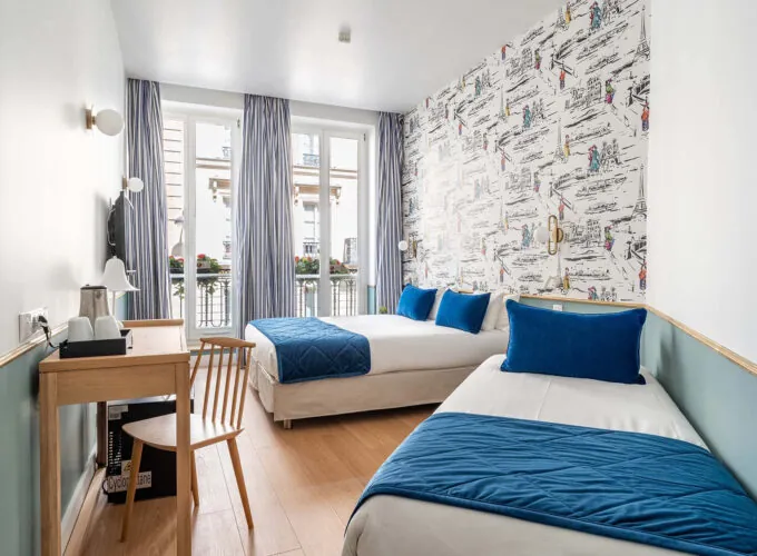 Chambre Triple avec deux lits et un bureau à l’hôtel Acadia