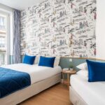 Chambre Triple avec deux lits et un tableau accroché au mur à l’hôtel Acadia