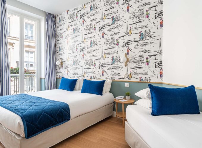 Chambre Triple avec deux lits et un tableau accroché au mur à l’hôtel Acadia