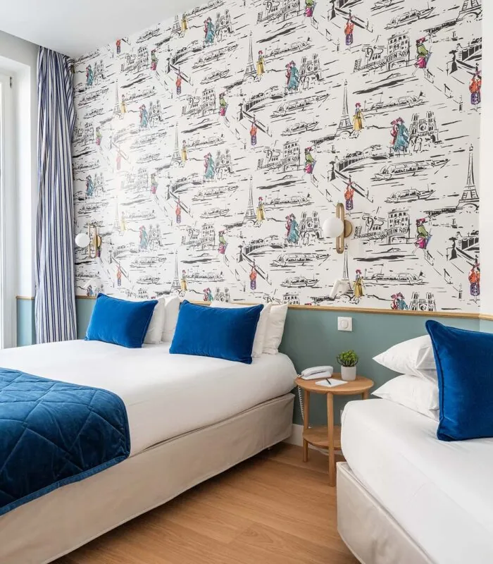 Chambre Triple avec deux lits et un tableau accroché au mur à l’hôtel Acadia