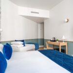 Chambre Triple avec deux lits et une télévision à écran plat à l’hôtel Acadia