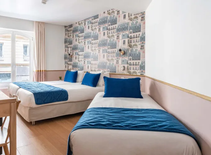 Chambre Triple avec deux lits et des oreillers bleus à l’hôtel Acadia