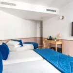 Chambre triple avec deux lits et une télévision à écran plat à l’Hôtel Acadia