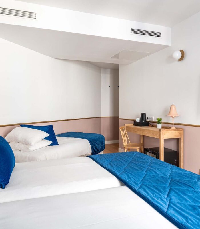 Chambre triple avec deux lits et une télévision à écran plat à l’Hôtel Acadia