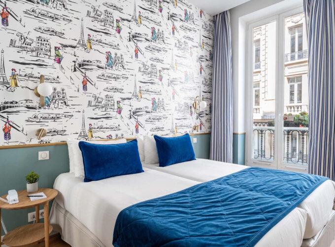Chambre Twin avec deux lits et une couverture bleue à l’hôtel Acadia