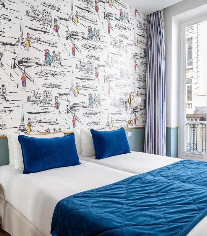 Chambre Twin avec deux lits et une couverture bleue à l’hôtel Acadia
